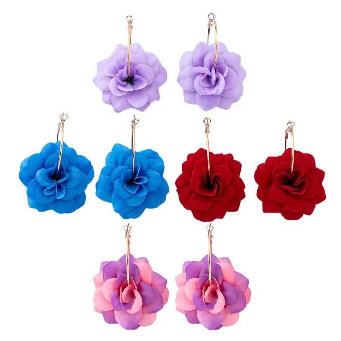 Une paire de boucles d'oreilles créoles pour femme avec fleurs en tissu tridimensionnelles rouges, idéales pour le quotidien et les vacances