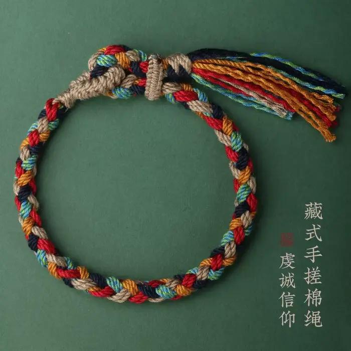 Bracelet en corde de coton tressée tibétaine fait main avec pompon – Bijou ethnique bohème pour la f