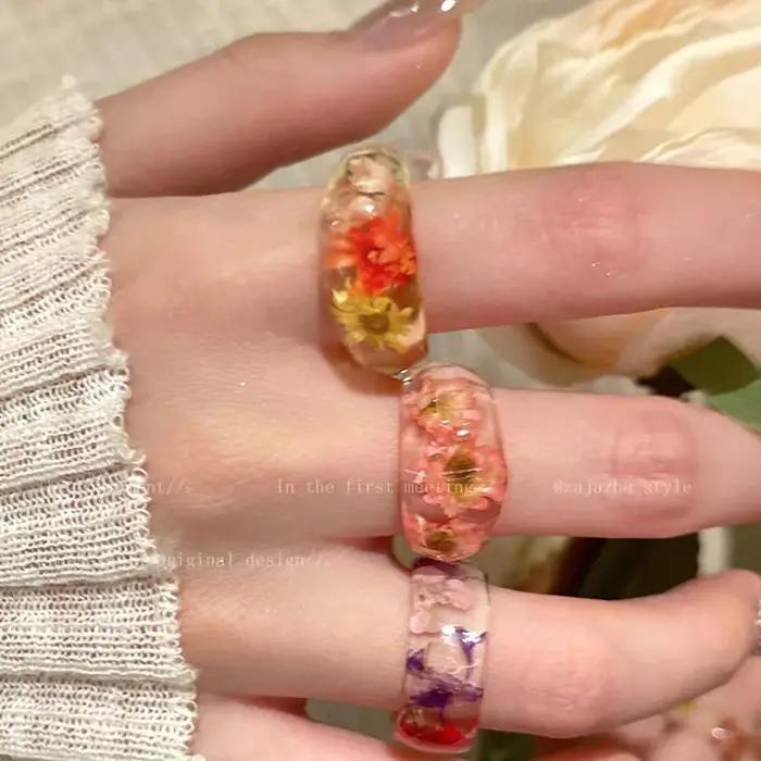 Bague en résine minimaliste exquise avec fleur séchée marguerite