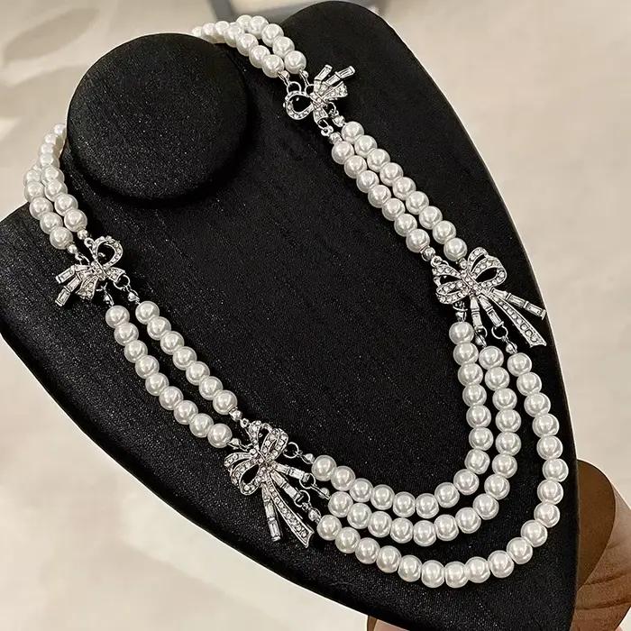 Collier français multicouche avec perles et nœud en diamant