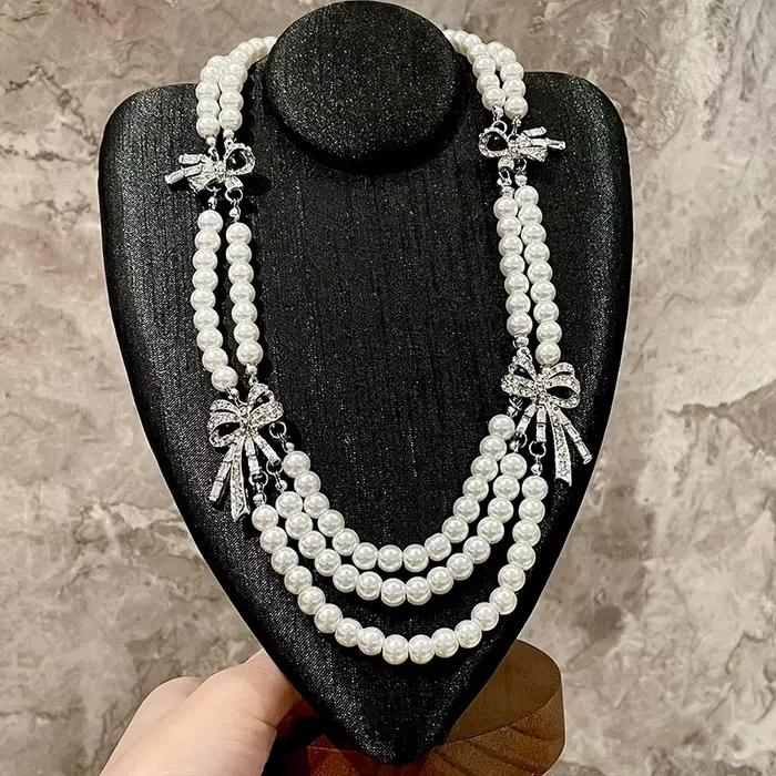 Collier français multicouche avec perles et nœud en diamant