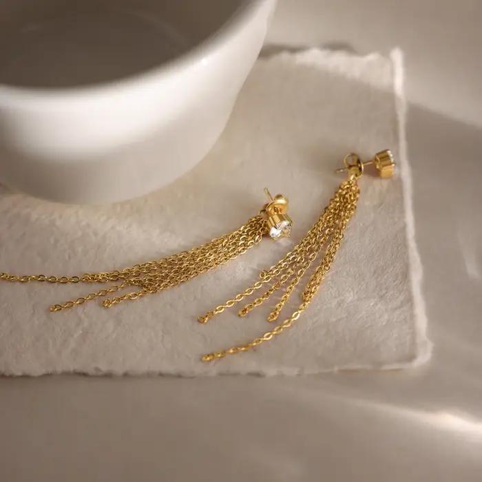 Boucles d'oreilles pendantes Zora en acier inoxydable plaqué or 18 carats PVD avec zircon et pompon