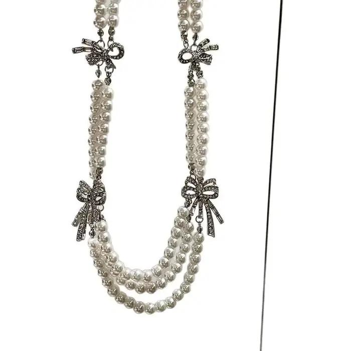 Collier français multicouche avec perles et nœud en diamant
