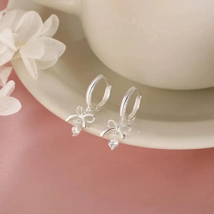 Cette exquise boucle d'oreille en forme de papillon incurvée avec pompon est en argent 925 et est un bijou haut de gamme.