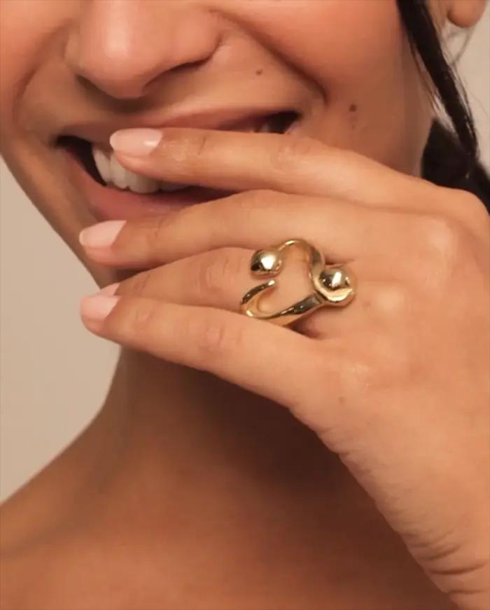 Bague d'art dorée en forme d'amour : une gros plan de bijoux romantiques de style métal avec un sens du design unique