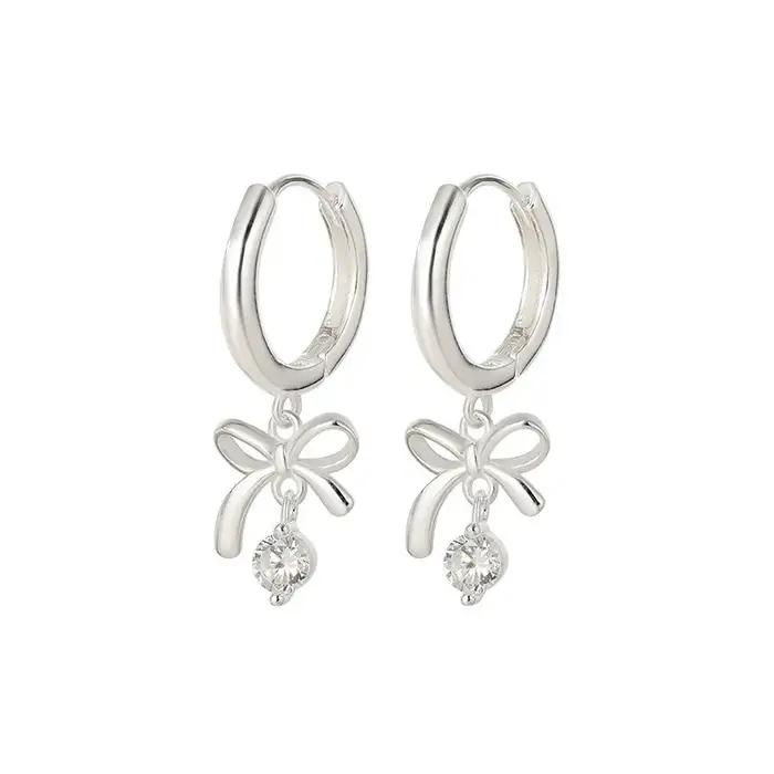 Cette exquise boucle d'oreille en forme de papillon incurvée avec pompon est en argent 925 et est un